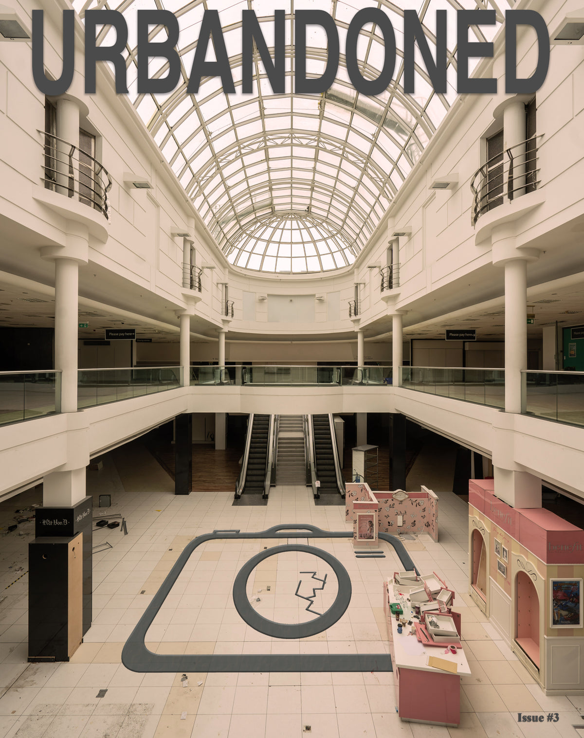 Front cover of Urbandoned Issue 3 showing a deserted shopping centre beneath a glass roof