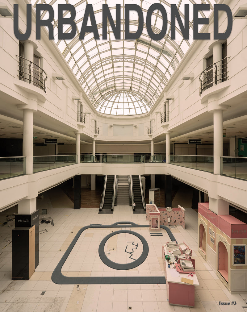 Front cover of Urbandoned Issue 3 showing a deserted shopping centre beneath a glass roof